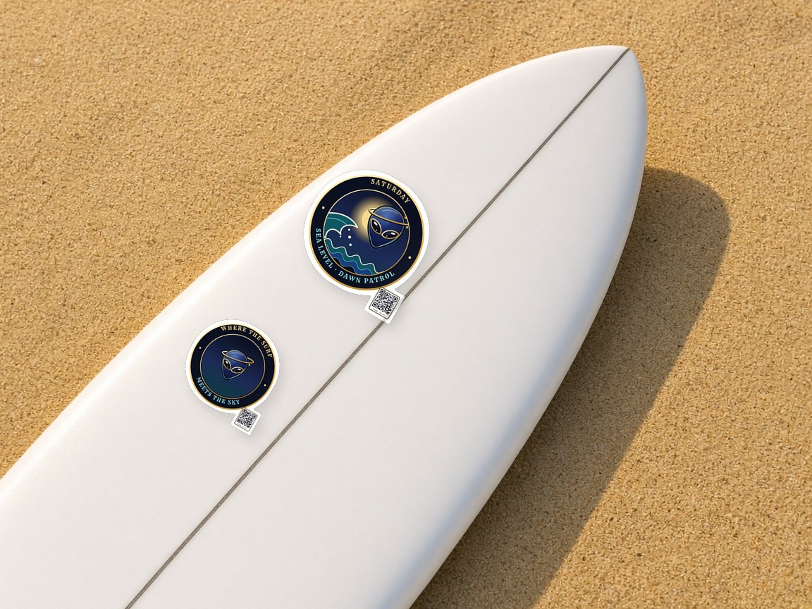 Dawn Patrol and Surf Meets Sky stickers on the nose of a white surfboard in the sand